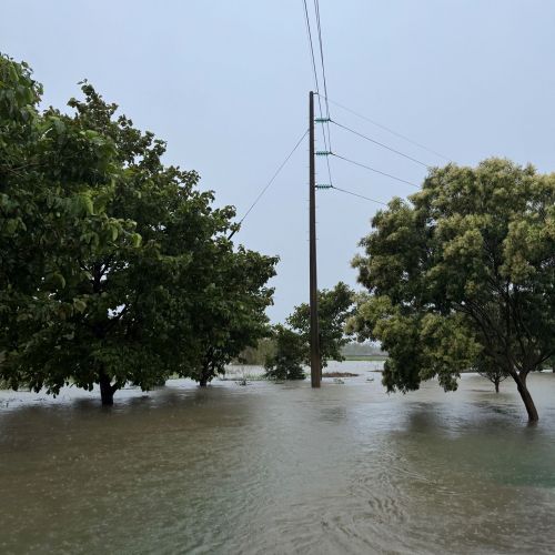 A flooded street with a power pole