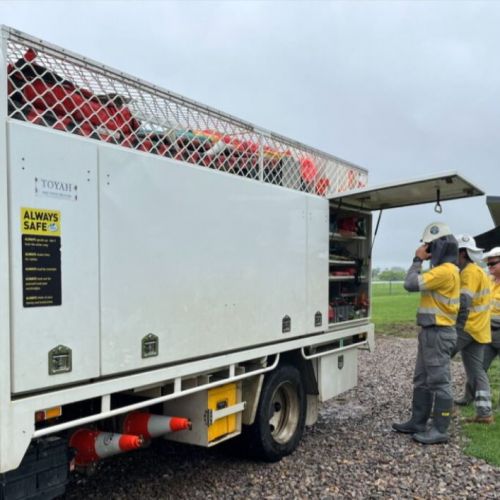 Workers standing next to crew work truck