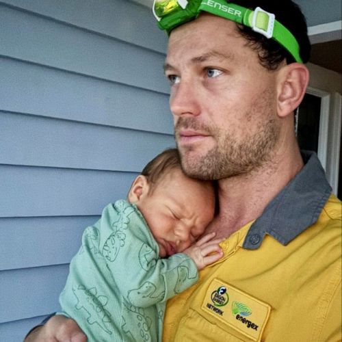 Field crew member with baby at front of house