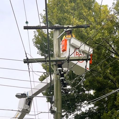 Crew member in cherry picker working on powerlines