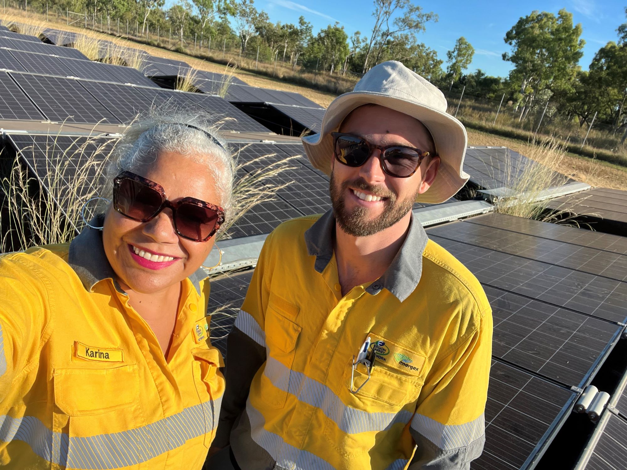 Ergon Energy workers standing in front of solar panels at Doomadgee solar farm site