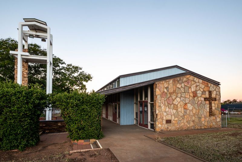 Church building front and sign at sunset