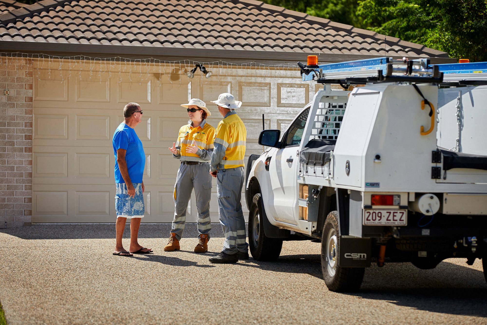 Crew talking to a customer in their driveway at home