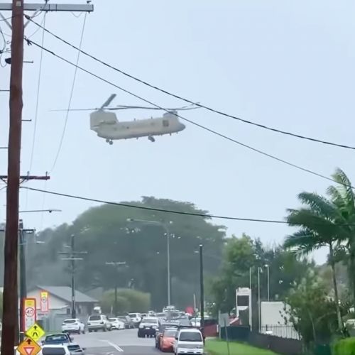 Chinook in the air with a strap holding a generator