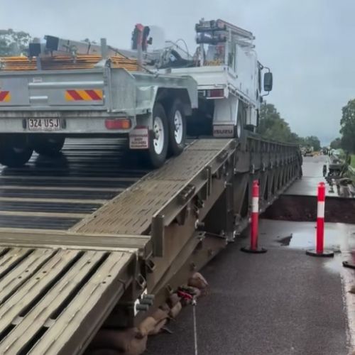 Work truck crossing temporary bridge at Ollera Creek