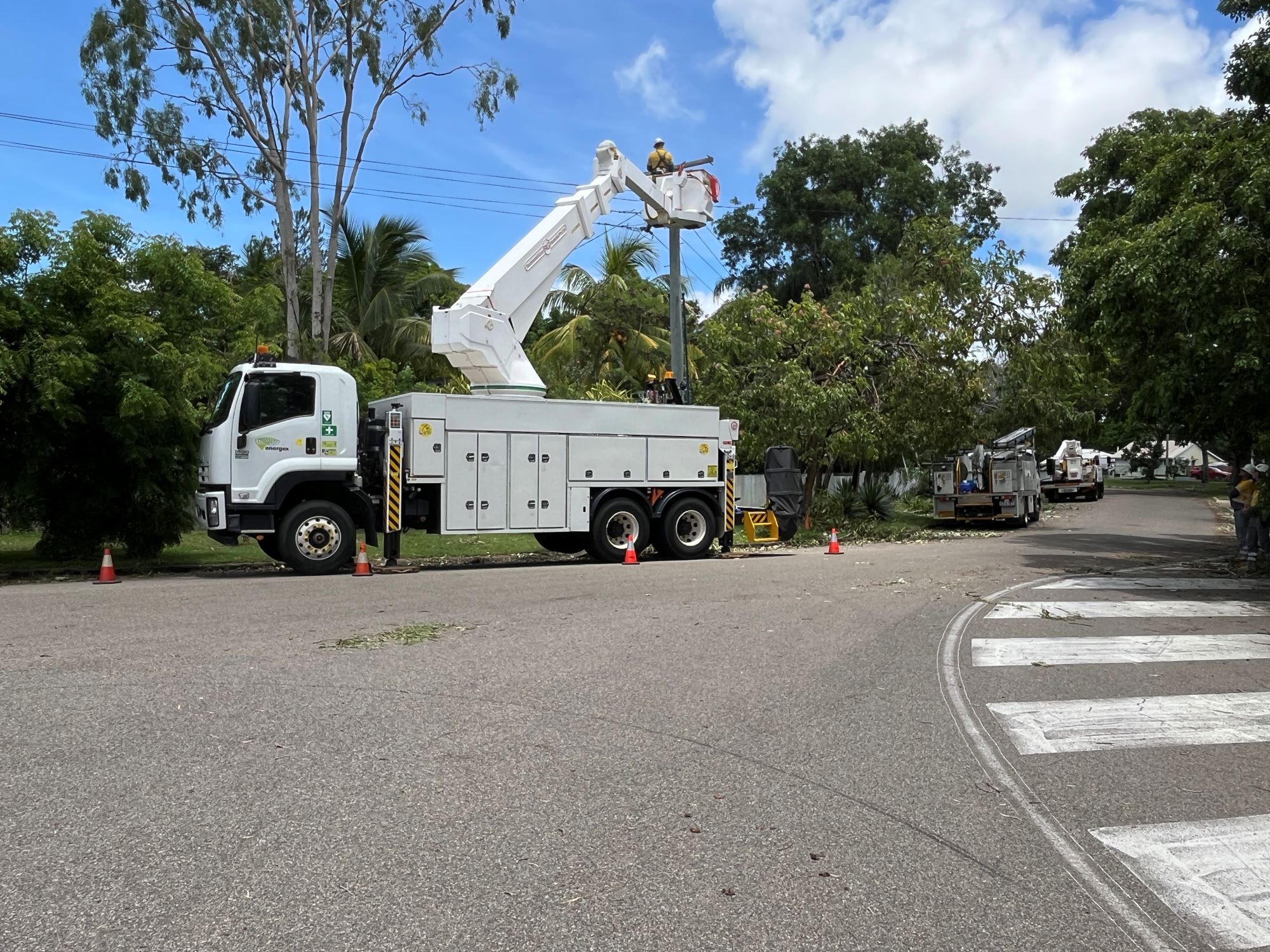 Crews working on pole cherry picker in a street after Cyclone Kirrily