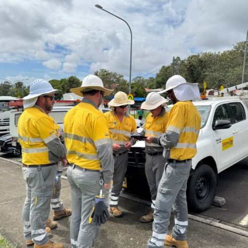 Group of field crew in front of vehicle looking at a map