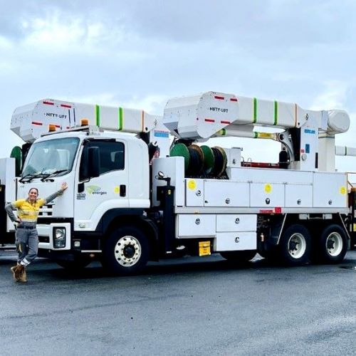 Crew member leaning in front of an Energex truck