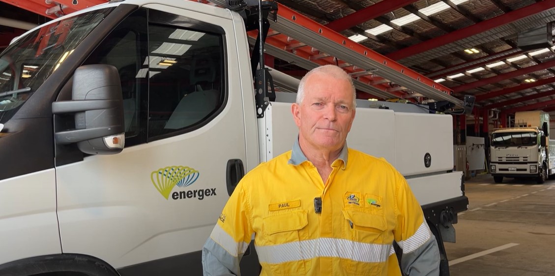 Paul Jordan in a depot in front of work vehicles