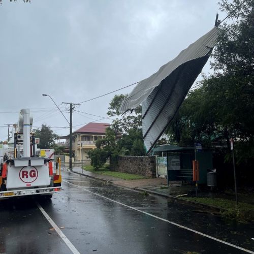 A bit of tin roof wrapped around powerlines over a road