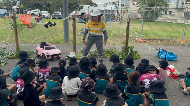 A crew member presenting in front of school children for Safety Heroes program