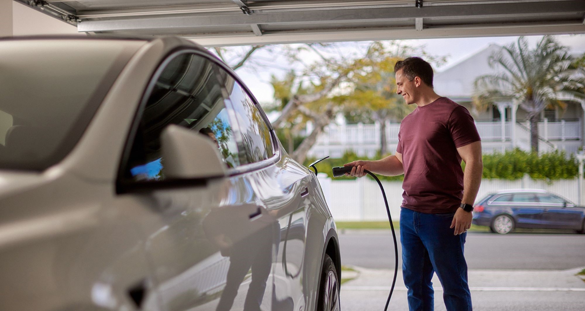 Man charging EV inside garage