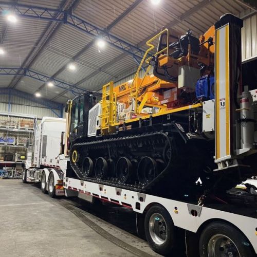 Truck with a tractor as the load inside a warehouse