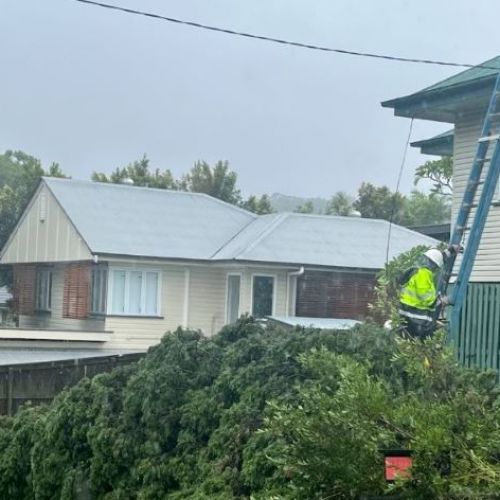 Work crew on ladder to roof of house repairing a service line