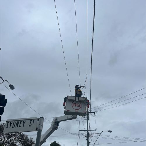 Crew member in cherry picker working on powerlines