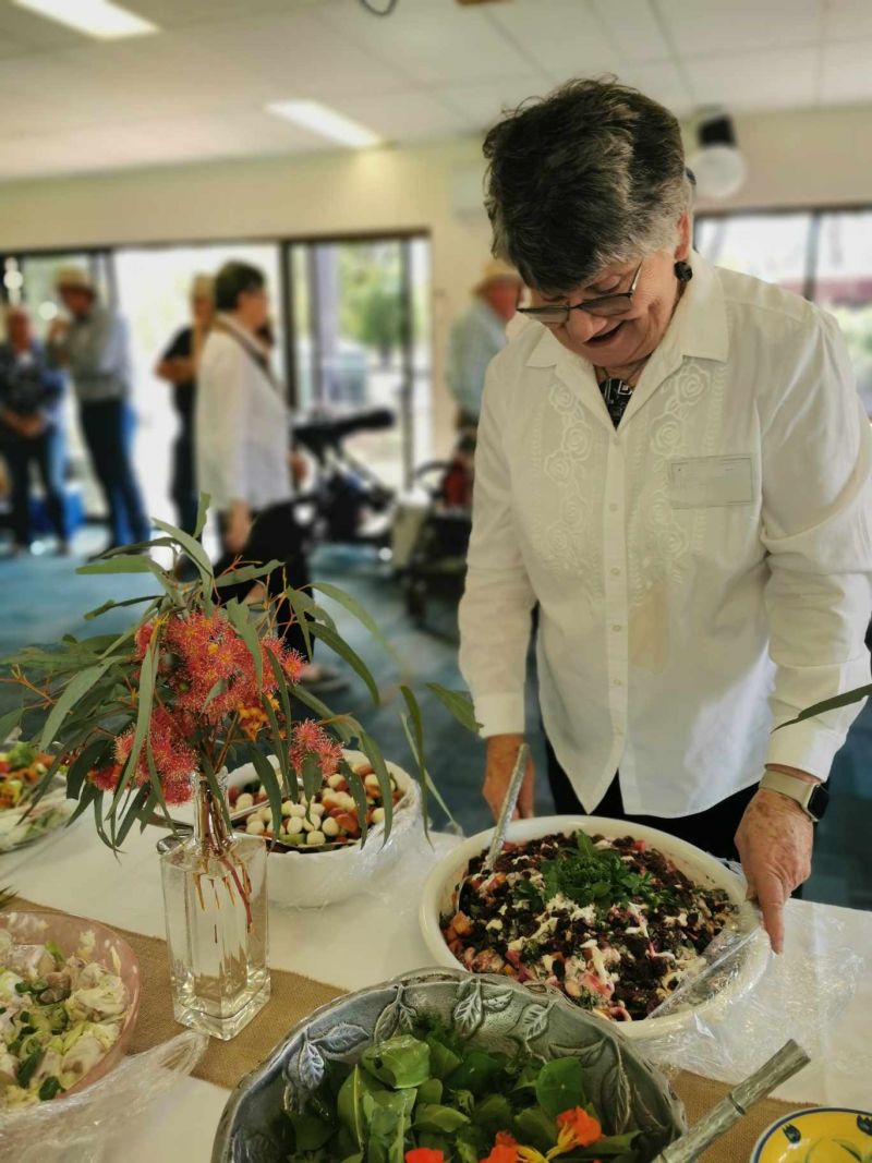 Woman placing a plate of food on banquet table