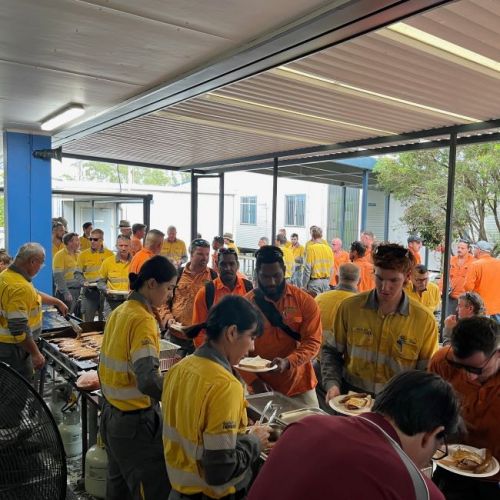  A number of worker line up for breakfast at a buffet style setup