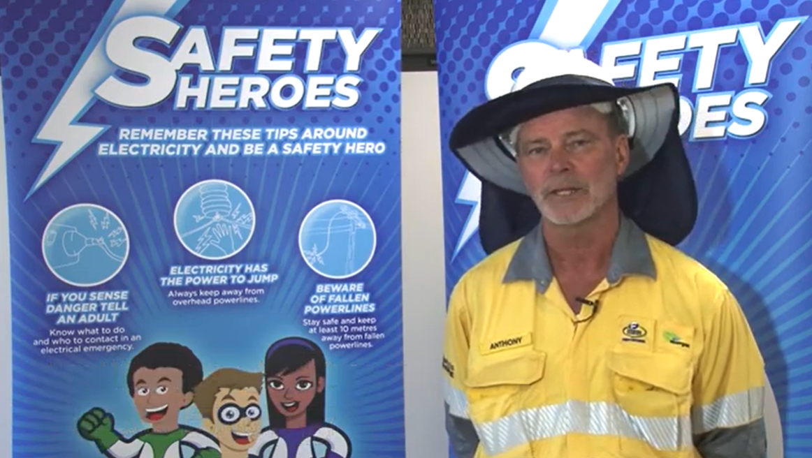 Field crew worker in front of Safety Heroes signage