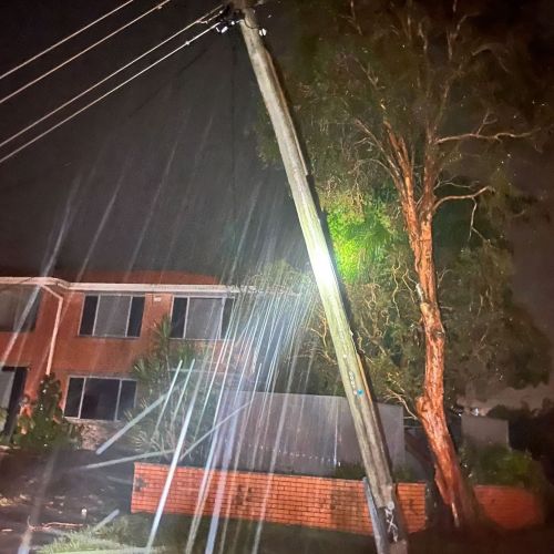 Leaning power pole in front of houses